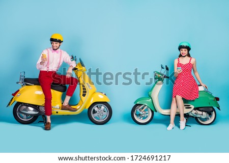 Full body photo of funny lady guy two people sitting vintage moped vacation together short stop browsing telephones bloggers wear retro clothes headgear isolated blue color background