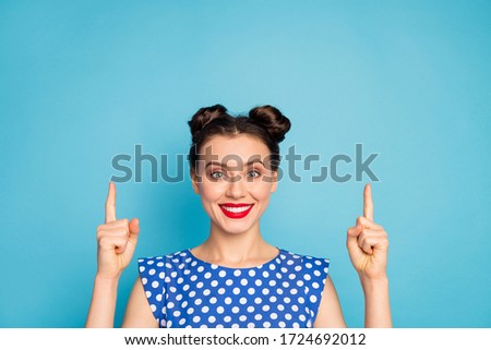 Closeup photo of pretty lady directing fingers up empty space advising low shopping prices excited cool proposition wear dotted white blouse shirt isolated blue color background