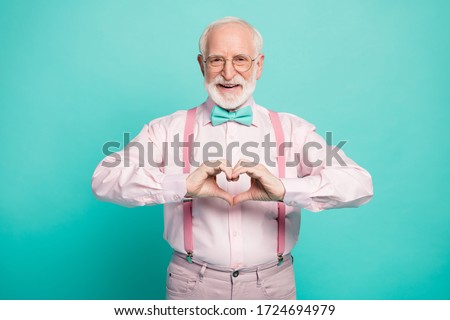 Photo of attractive grandpa making heart figure fingers hands inviting wife romance date wear specs pink shirt suspenders bow tie trousers isolated teal color background
