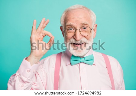 Closeup photo of amazing grey haired grandpa showing okey symbol express agreement wear specs pink shirt suspenders bow tie isolated bright teal color background Royalty-Free Stock Photo #1724694982