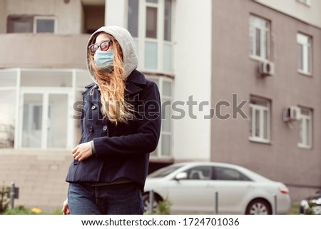Closeup portrait of a girl in a medical mask on the street, epidemic of a coronavirus. The man violated the rules of self-isolation. SARS-CoV-2. protect yourself from COVID-19.