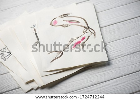 High angle view of paper with Japanese painting on wooden surface