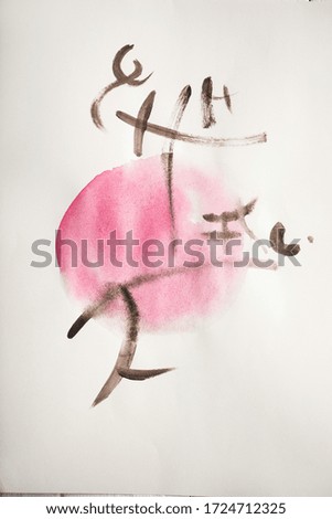 Top view of paper with japanese painting with hieroglyphs on pink circle