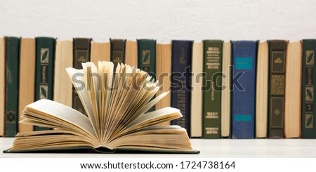 Composition with vintage old hardback books, diary, fanned pages on wooden deck table and abstract background. Books stacking. Back to school. Copy Space. Education background.