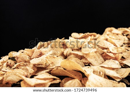 Potato chips on a black background, shallow depth of field, selective focus.