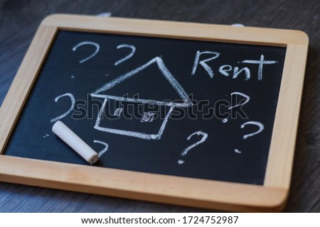 Word 'Rent' written on a chalk board representing the struggle of paying rent during the pandemic  Royalty-Free Stock Photo #1724752987