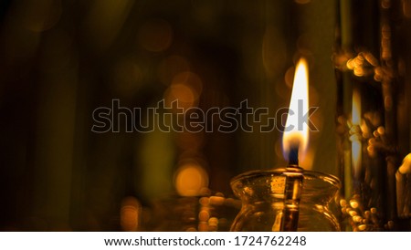 Chanukah oil candle on a silver menorah with one candle lit
