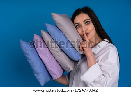 The girl in The white shirt with the dissolved hair with some small pillows, put pillow head and gestures quietly.
