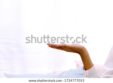Hand of woman holding or presenting something on the palm of her hand on white background with copy space. Hand showing your product concept.