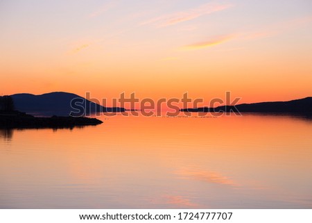 East view of the St. Lawrence River just before sunrise, with Cape Tourmente and the Island of Orleans seen in silhouette from Sainte-Anne-de-Beaupré, Quebec, Canada Royalty-Free Stock Photo #1724777707