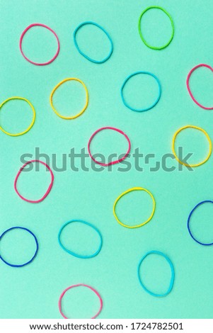 Thin multicolored elastic bands on plain background. 
