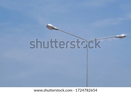 Street lighting bulb in daytime with blue sky close-up.