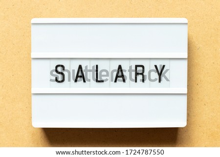 Lightbox with word salary on wood background