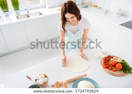Photo of beautiful cheerful housewife enjoy hobby preparing family recipe dinner forming making dough for pizza modern kitchen indoors casual clothing