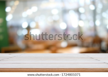 Empty brown wooden table and blur background of resturant, can be used for montage or display your products