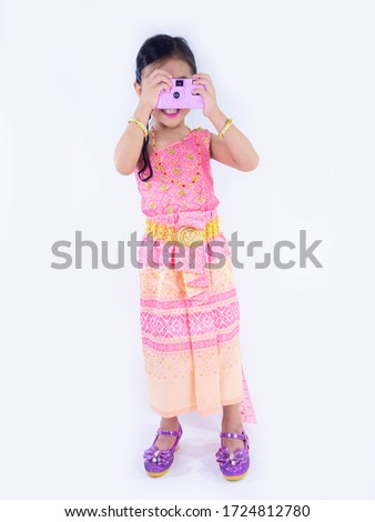 children girl in pink Thai dress  Taking pictures by film camera  on white background