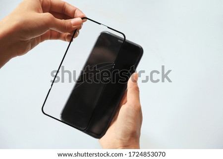 hand showing broken film screen protection for changing to new with smartphone. technology activity concept 