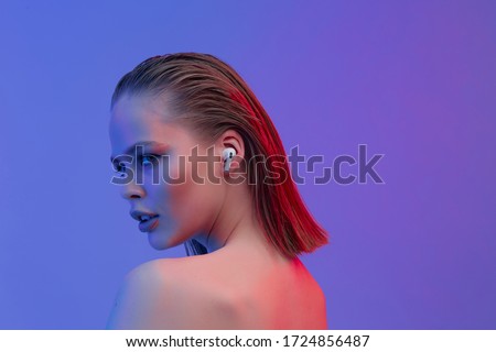 A beautiful young girl in wireless headphones listens to song with a good mood. bright colorful music poster. Royalty-Free Stock Photo #1724856487