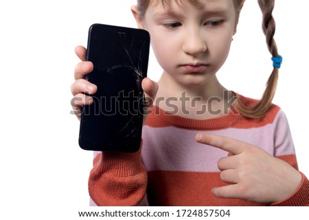 Cute little girl with broken smartphone on white background