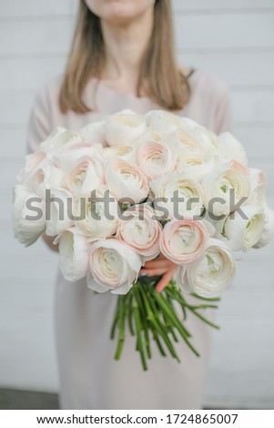 Tender pastel peony roses bouquet in girl's hands 