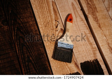 brushing wood with varnish, film and grain photo