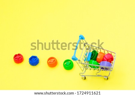 Mini trolley with plastic caps. multi-colored plastic corks from baby food, zero life-style waste, recycling garbage, environmental awareness