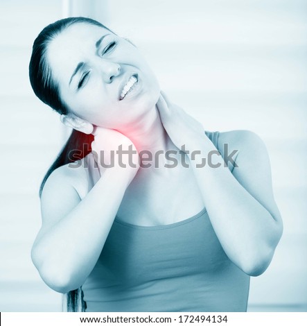 young brunette woman with a pain in the neck, monochrome photo with red as a symbol for the hardening