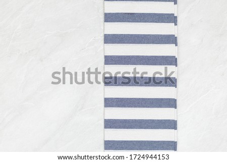 Kitchen dishtowel background above white marble copy space.