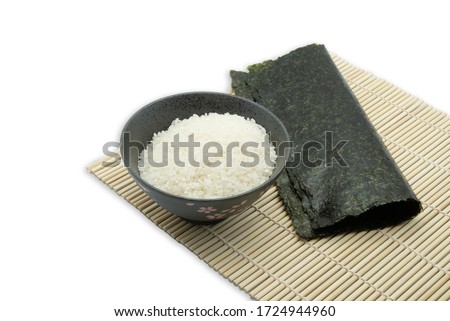Seaweed sheet and rice on bamboo mat on white background. Japanese sushi ingredients