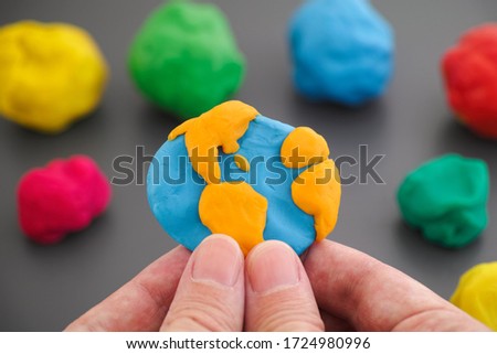 Man holding planet Earth in his hands. Planet Earth is made out of play clay (plasticine).