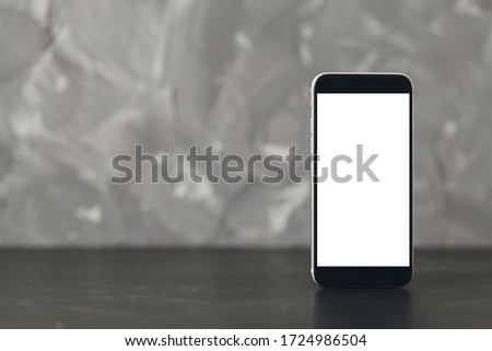 Mobile phone with blank screen on black wooden table background. copy space