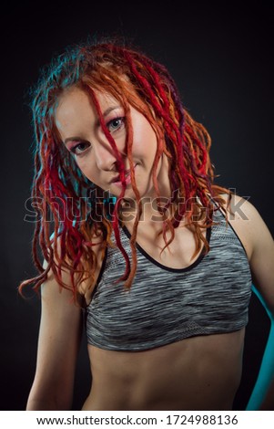 Beautiful young red-haired  woman with dreadlocks hairstyle .