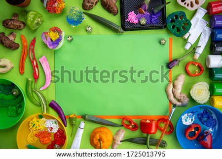 blank paper sheet; artistic picture with a green background, colorful paint, vegetables stamps and craft paper;