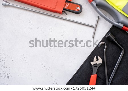 car emergency kit - warning triangle danger sign, first aid kit and reflective vest, metal hook part of the Jack device, wrench and hexagon concept-car care, accident prevention.