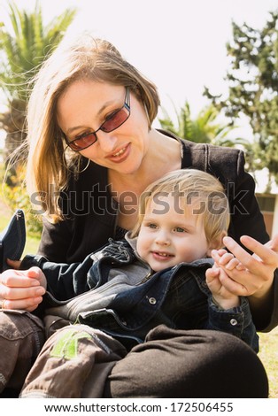 Cute little boy playing with his mother in the park