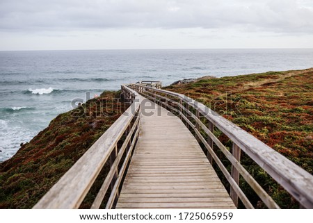 photo of a wooden pier leading to the coast