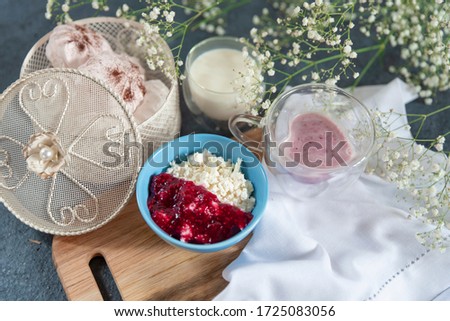 
fresh cheese in a blue bowl, yogurt in a glass and a glass of milk