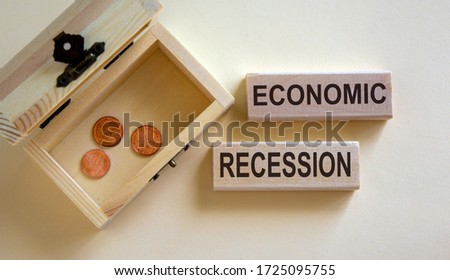 Concept words 'economic recession' on blocks on a beautiful white background, small chest with coins.
