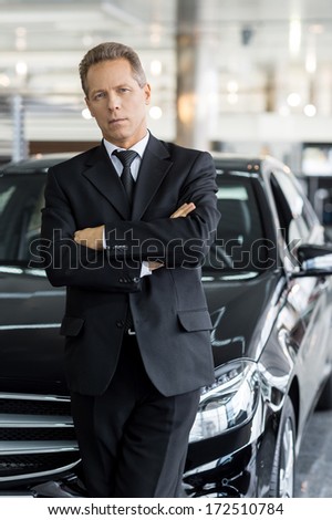 I choose only the best. Confident grey hair man in formalwear standing in front of car and looking at camera