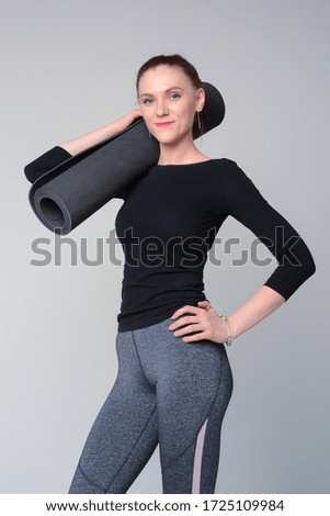 the girl with yoga mat on the light background