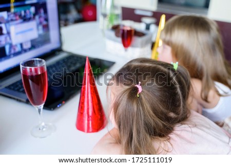 Kids online birthday party.Little girls in dresses, red hat celebrate holiday with friends. Conference,video call in laptop, computer.Animator, juice, cookies.Quarantine,coronavirus pandemic covid-19.