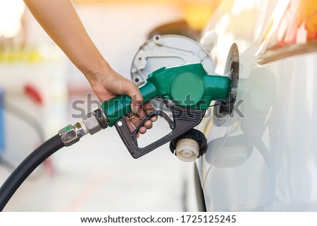 Hand Man Refill and filling Oil Gas Fuel at station. Gas station - refueling. To fill the machine with fuel. Car fill with gasoline at a gas station. Gas station pump.  Royalty-Free Stock Photo #1725125245