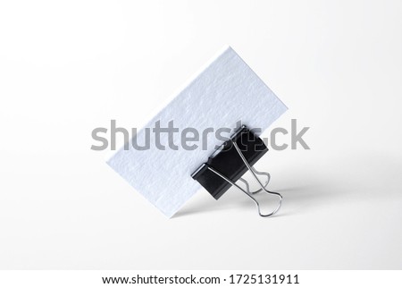Blank letterpress business cards stack in the clamp isolated on white high view as template for design presentation, logo embossing, mock-up etc.