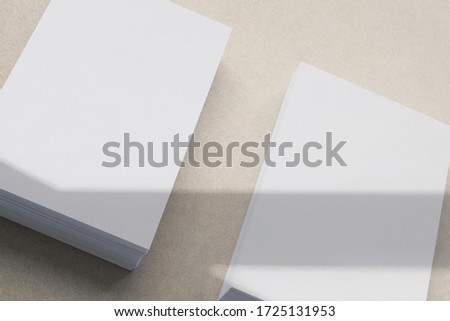 two blank business card stacks, poster, letterheads on brown background with shadow overlay as template for design presentation, mock-up etc.