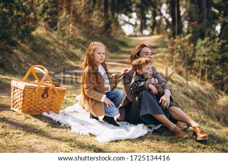 Mother with kids having picnic in the forest