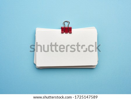 stack of rectangular white paper blank business cards on blue background, top view Royalty-Free Stock Photo #1725147589