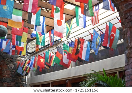Image of small flags hanging from the ceiling and wall of different states,country.