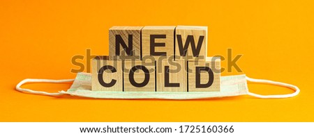 NEW COLD the word is written on wooden cubes lying on a medical mask. Concept