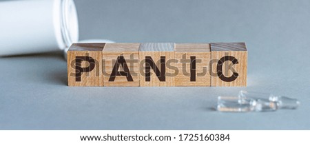 PANIC - words from wooden blocks with letters, feel worried and nervous stress concept, top view light background