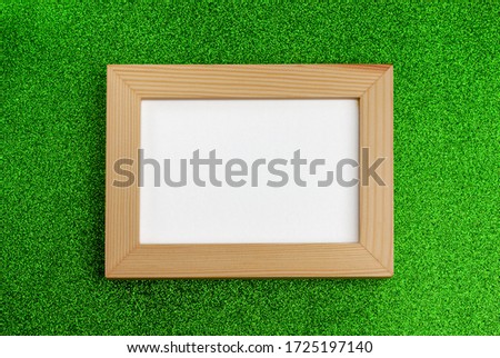 Wooden photo frame on a green background